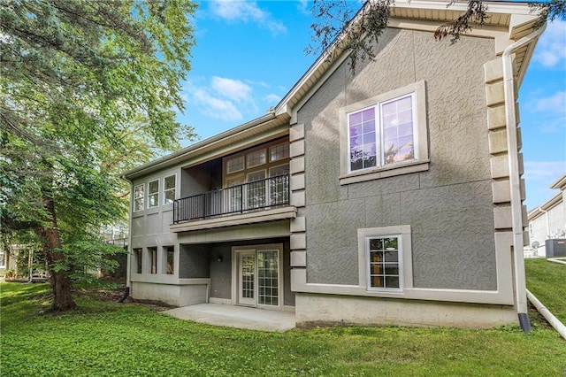 812 E 110th Ter, Kansas City, MO 64131 - rear view of property featuring a balcony, stucco siding, a lawn, and a patio area
