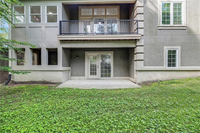 812 E 110th Ter, Kansas City, MO 64131 - back of house with a balcony, stucco siding, a lawn, and french doors