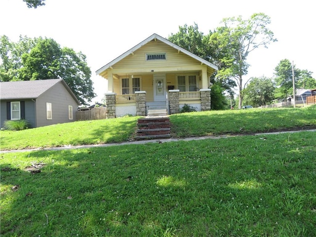 201 E Ottawa St, Paola, KS 66071 - view of front facade featuring covered porch, a front lawn, stone siding, and stairs
