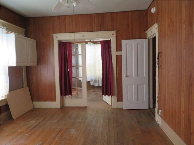201 E Ottawa St, Paola, KS 66071 - spare room with ceiling fan, wood walls, and light wood-type flooring