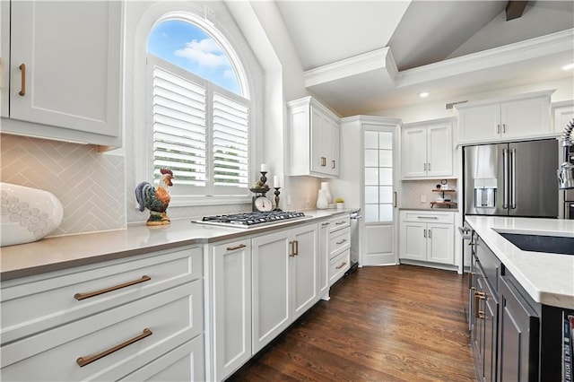 9905 W 144th St, Overland Park, KS 66221 - kitchen with appliances with stainless steel finishes, lofted ceiling, white cabinetry, decorative backsplash, and crown molding