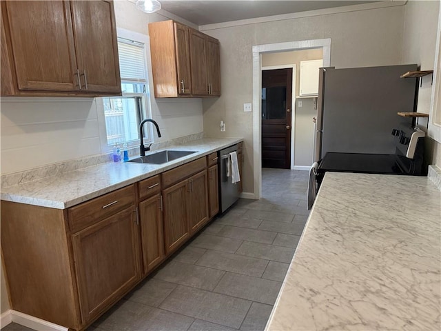 612 W Walnut St, Independence, KS 67301 - kitchen with a sink, appliances with stainless steel finishes, light countertops, and brown cabinetry