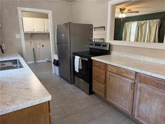 612 W Walnut St, Independence, KS 67301 - kitchen with stainless steel electric range oven, a ceiling fan, light countertops, white cabinetry, and tile patterned flooring