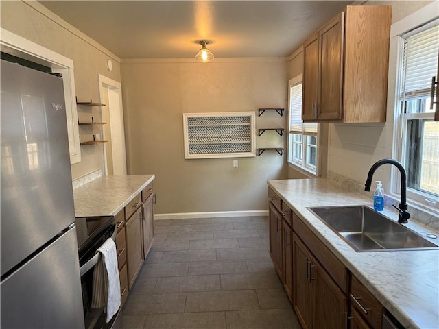 612 W Walnut St, Independence, KS 67301 - kitchen with stainless steel appliances, a sink, light countertops, baseboards, and open shelves