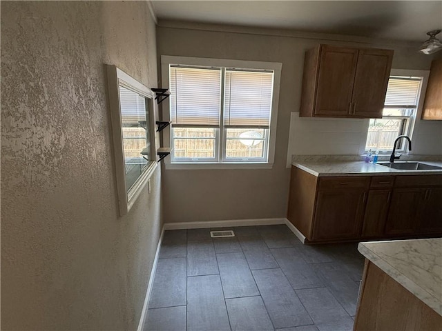612 W Walnut St, Independence, KS 67301 - kitchen with healthy amount of natural light, light countertops, and brown cabinetry