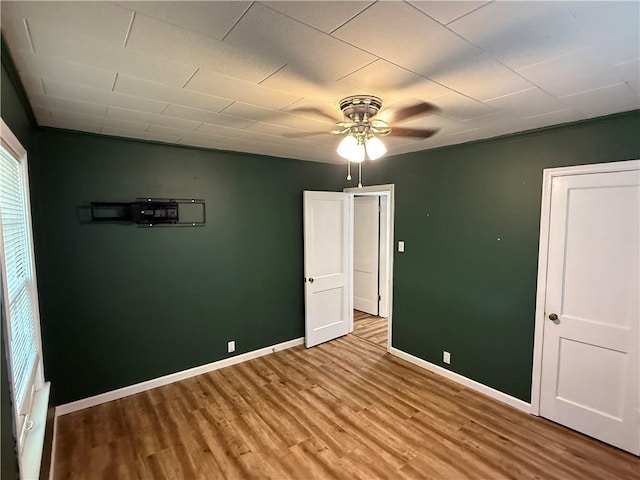 612 W Walnut St, Independence, KS 67301 - unfurnished bedroom with wood finished floors, baseboards, and a ceiling fan