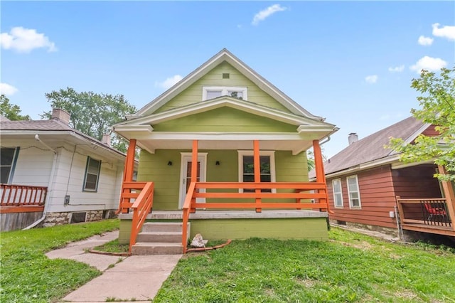 2717 Bales Ave, Kansas City, MO 64128 - shotgun-style home featuring a porch and a front yard
