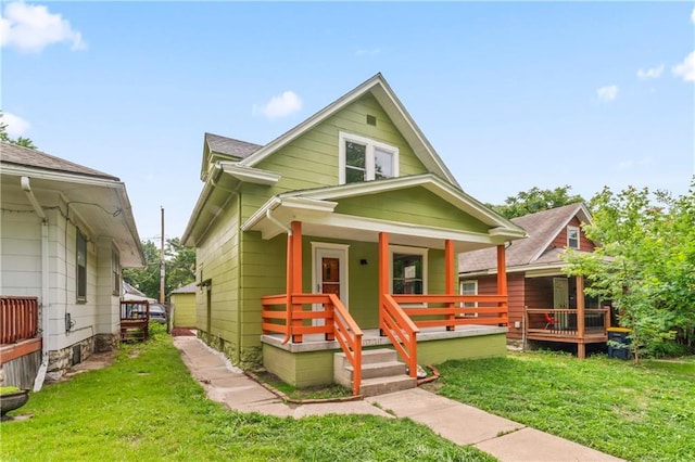 2717 Bales Ave, Kansas City, MO 64128 - view of front of house with a porch and a front lawn