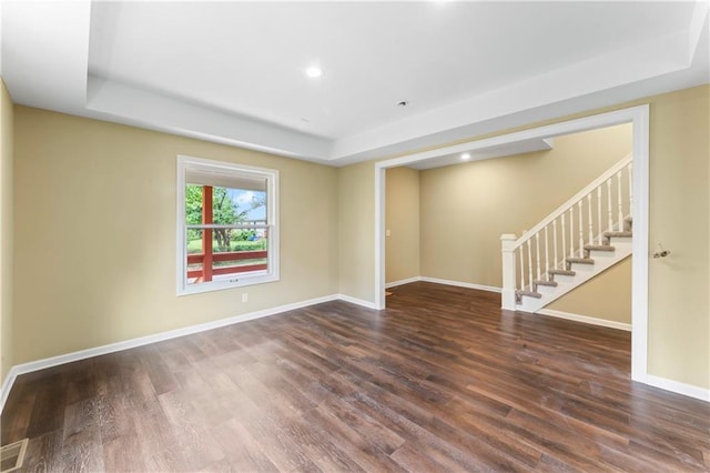 2717 Bales Ave, Kansas City, MO 64128 - spare room with a raised ceiling, stairway, wood finished floors, and recessed lighting