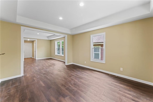 2717 Bales Ave, Kansas City, MO 64128 - spare room featuring dark wood-style flooring, a tray ceiling, and recessed lighting