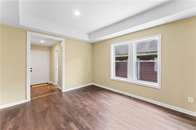 2717 Bales Ave, Kansas City, MO 64128 - spare room with wood finished floors, a tray ceiling, and recessed lighting