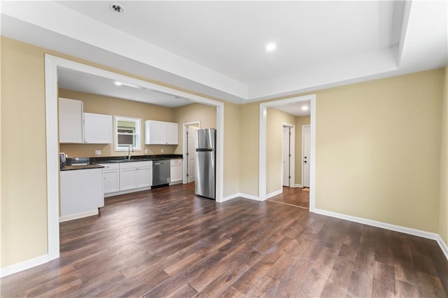 2717 Bales Ave, Kansas City, MO 64128 - kitchen featuring appliances with stainless steel finishes, dark countertops, dark wood-type flooring, white cabinets, and recessed lighting