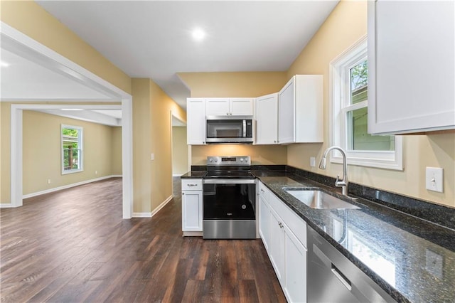 2717 Bales Ave, Kansas City, MO 64128 - kitchen featuring appliances with stainless steel finishes, dark wood finished floors, white cabinets, and dark stone countertops