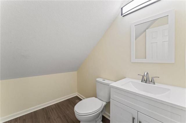 2717 Bales Ave, Kansas City, MO 64128 - bathroom featuring vanity, wood finished floors, vaulted ceiling, and a textured ceiling