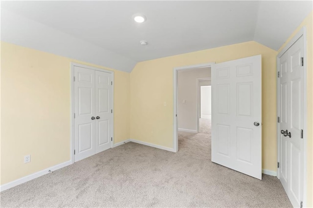 2717 Bales Ave, Kansas City, MO 64128 - unfurnished bedroom with lofted ceiling, light carpet, and a closet