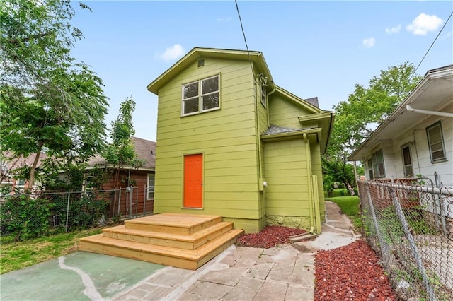 2717 Bales Ave, Kansas City, MO 64128 - back of house with a shingled roof and a patio