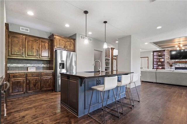 4529 Lakecrest Dr, Shawnee, KS 66218 - kitchen with stainless steel refrigerator with ice dispenser, dark countertops, a breakfast bar, dark wood-type flooring, and an island with sink