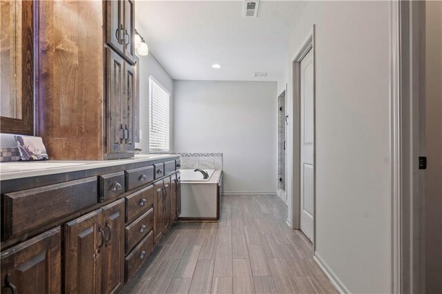 4529 Lakecrest Dr, Shawnee, KS 66218 - bathroom with a garden tub, double vanity, wood finished floors, and recessed lighting