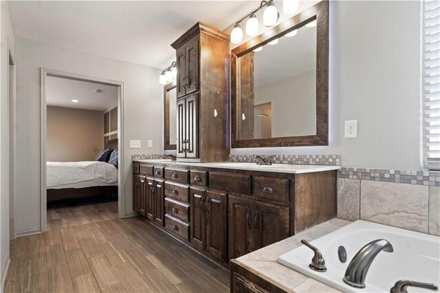 4529 Lakecrest Dr, Shawnee, KS 66218 - bathroom featuring double vanity, a bath, wood finished floors, and ensuite bath