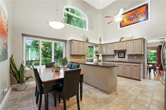 12032 Ballentine St, Overland Park, KS 66213 - kitchen featuring a high ceiling, tasteful backsplash, light tile patterned flooring, a ceiling fan, and a peninsula