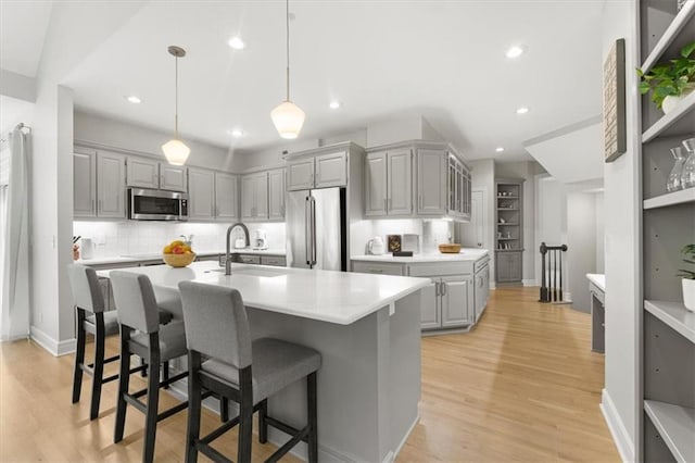 6205 W 149th St, Overland Park, KS 66223 - kitchen with appliances with stainless steel finishes, gray cabinets, light countertops, backsplash, and recessed lighting