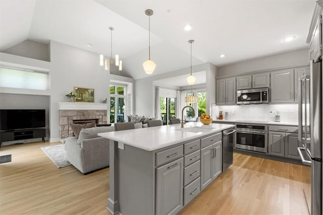 6205 W 149th St, Overland Park, KS 66223 - kitchen with gray cabinets, appliances with stainless steel finishes, lofted ceiling, light countertops, and light wood-style flooring