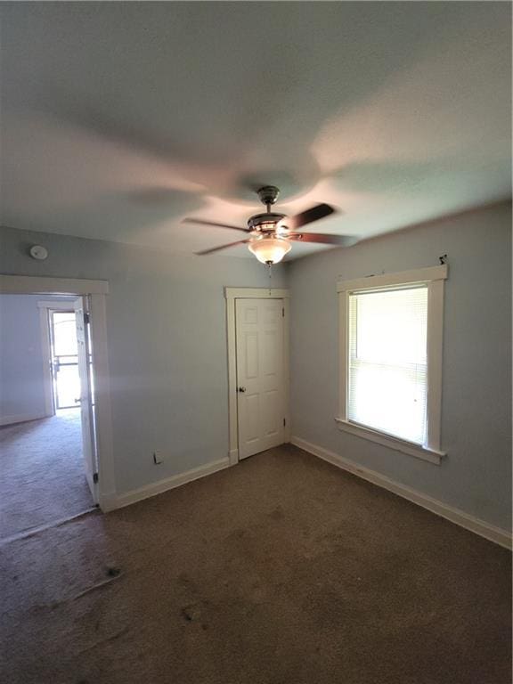 5000 Agnes Ave, Kansas City, MO 64130 - unfurnished room with dark carpet and ceiling fan