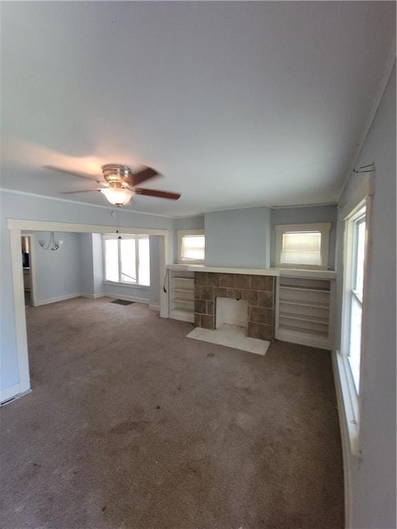 5000 Agnes Ave, Kansas City, MO 64130 - unfurnished living room featuring carpet flooring, a ceiling fan, and a tiled fireplace