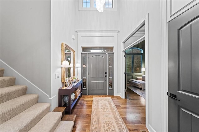 16600 Eby St, Overland Park, KS 66085 - entryway with a towering ceiling, wood finished floors, stairs, and a chandelier