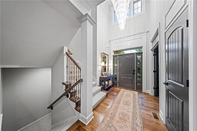 16600 Eby St, Overland Park, KS 66085 - foyer featuring stairs, a towering ceiling, wood finished floors, a chandelier, and a textured ceiling