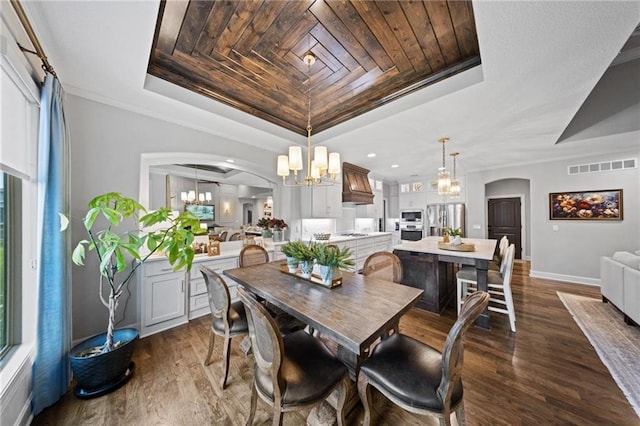 16600 Eby St, Overland Park, KS 66085 - dining space featuring a tray ceiling, a chandelier, arched walkways, dark wood-style floors, and wood ceiling
