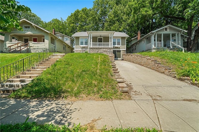 5016 Lydia Ave, Kansas City, MO 64110 - view of front of house featuring covered porch, stairway, and driveway