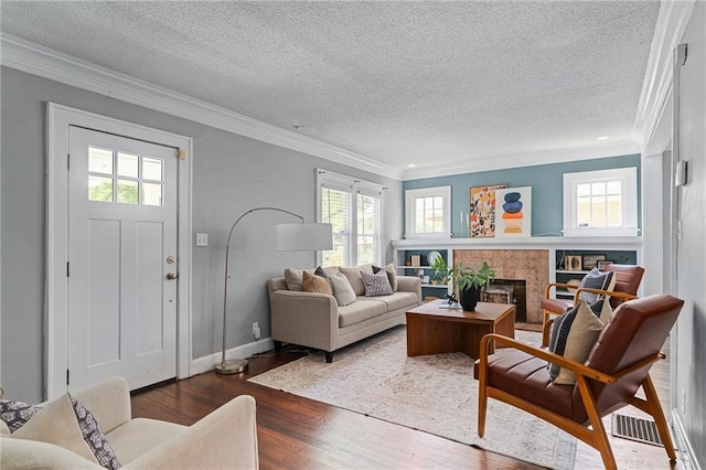 5016 Lydia Ave, Kansas City, MO 64110 - living area with crown molding, a textured ceiling, wood finished floors, and a glass covered fireplace