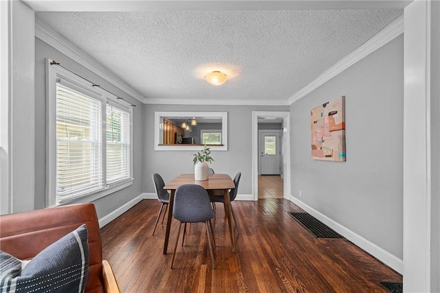 5016 Lydia Ave, Kansas City, MO 64110 - dining room featuring dark wood-type flooring, a textured ceiling, and ornamental molding