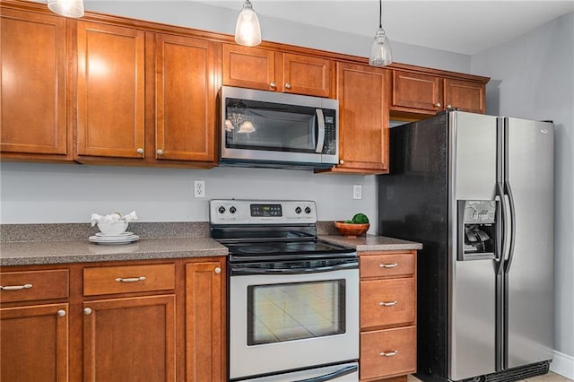 5016 Lydia Ave, Kansas City, MO 64110 - kitchen with stainless steel appliances, brown cabinets, dark countertops, and decorative light fixtures