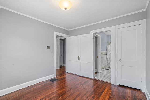 5016 Lydia Ave, Kansas City, MO 64110 - unfurnished bedroom featuring wood finished floors, crown molding, a textured ceiling, and connected bathroom