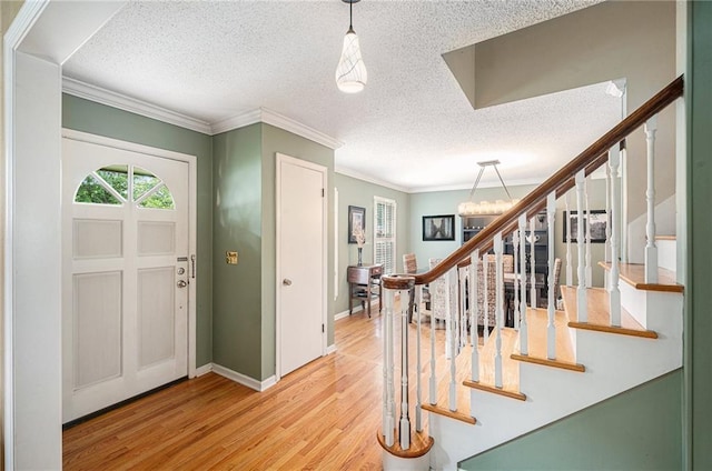 9412 Delmar St, Prairie Village, KS 66207 - entrance foyer featuring stairway, wood finished floors, a textured ceiling, ornamental molding, and a chandelier