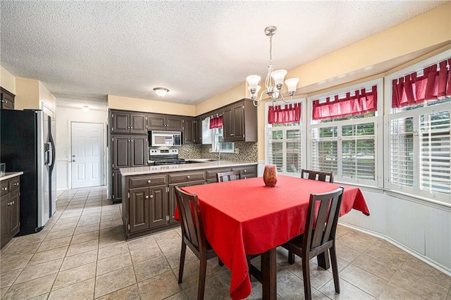 9412 Delmar St, Prairie Village, KS 66207 - dining space featuring a chandelier, a textured ceiling, and light tile patterned flooring