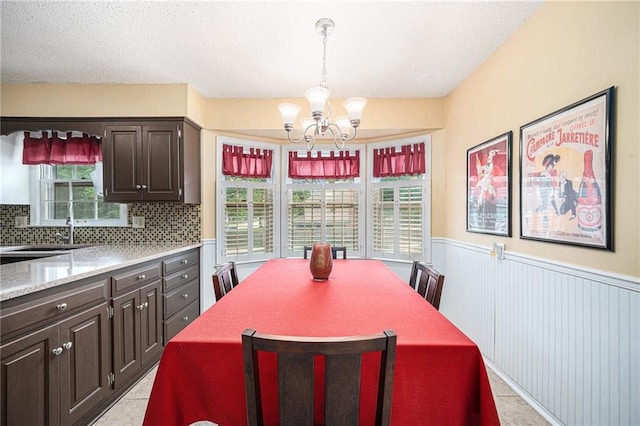 9412 Delmar St, Prairie Village, KS 66207 - dining area with a chandelier, wainscoting, and light tile patterned flooring