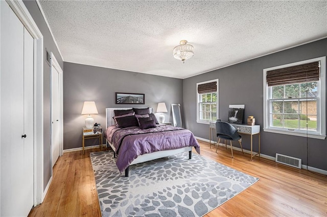9412 Delmar St, Prairie Village, KS 66207 - bedroom with a textured ceiling, wood finished floors, and a chandelier