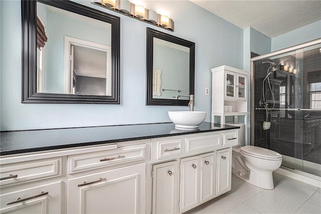 9412 Delmar St, Prairie Village, KS 66207 - bathroom featuring double vanity, a stall shower, tile patterned flooring, and a textured ceiling