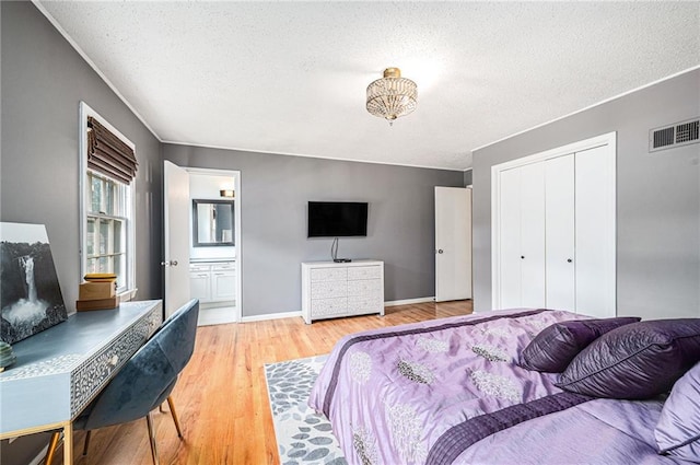9412 Delmar St, Prairie Village, KS 66207 - bedroom with a textured ceiling, light wood-style floors, a closet, and ensuite bath