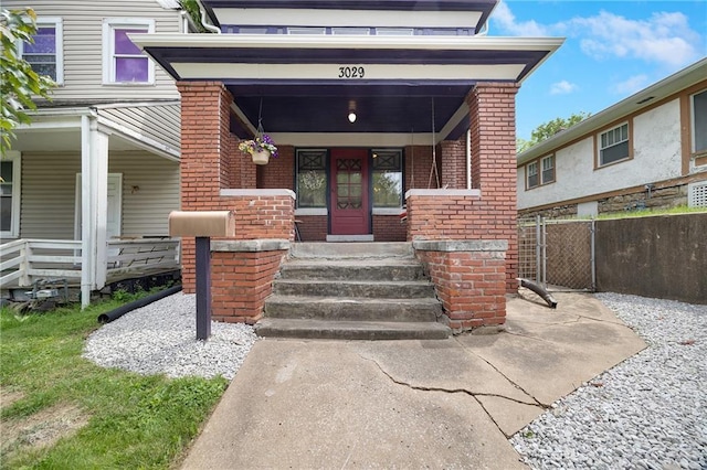 3029 E 7th St, Kansas City, MO 64124 - doorway to property featuring brick siding and covered porch