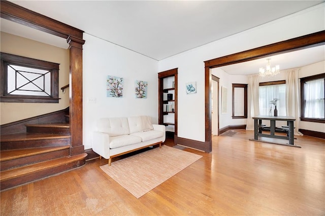 3029 E 7th St, Kansas City, MO 64124 - living room with light wood-style flooring, a chandelier, and stairway
