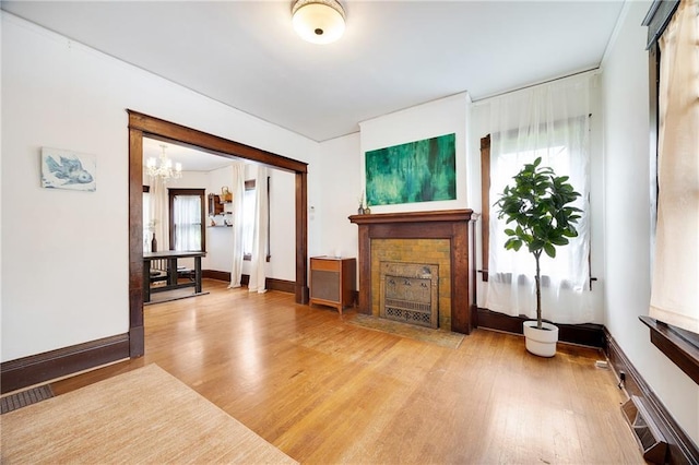 3029 E 7th St, Kansas City, MO 64124 - living room with a tiled fireplace, wood finished floors, and a chandelier