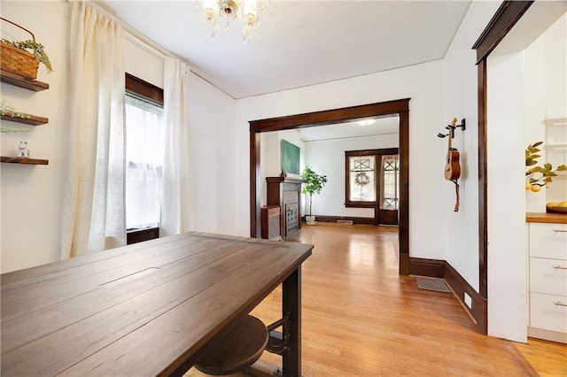 3029 E 7th St, Kansas City, MO 64124 - unfurnished dining area featuring a chandelier and light wood-type flooring
