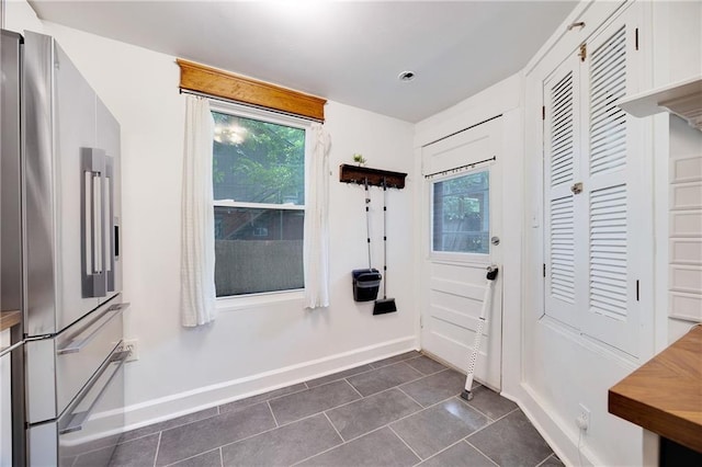 3029 E 7th St, Kansas City, MO 64124 - doorway to outside featuring dark tile patterned floors and plenty of natural light