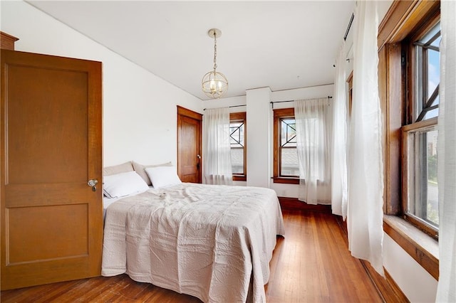3029 E 7th St, Kansas City, MO 64124 - bedroom with wood finished floors and a chandelier