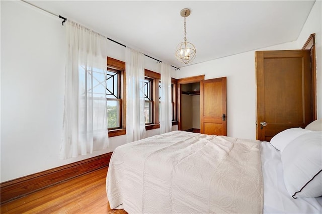 3029 E 7th St, Kansas City, MO 64124 - bedroom with light wood-style floors and a chandelier
