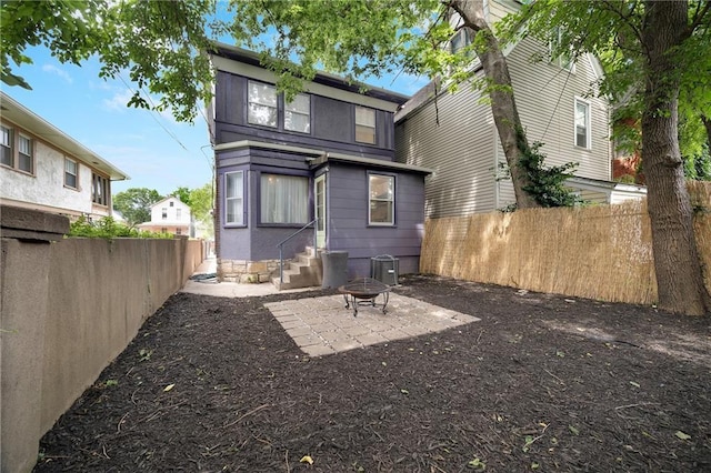 3029 E 7th St, Kansas City, MO 64124 - rear view of property with entry steps, a fenced backyard, a patio area, and an outdoor fire pit
